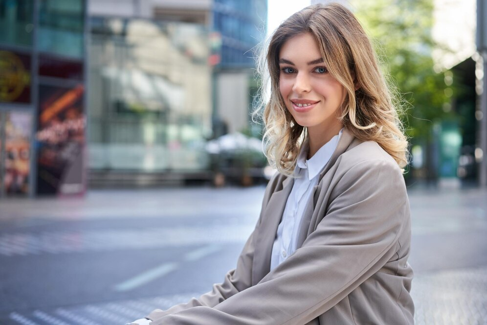 A woman posing for her professional headshot outside in comfortable yet professional clothes