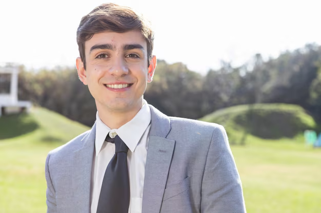 A young guy posing for his outdoor professional headshots with a smile on his face