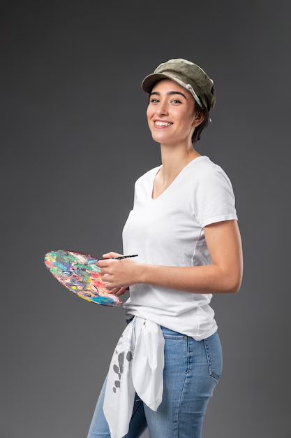 An artist headshot of a painter posing with her pain brushed and plate