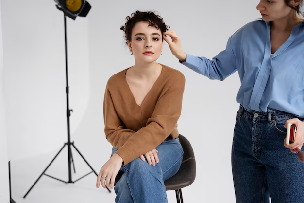 A woman posing for professional headshots in a studio setting