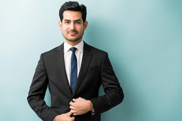 A good professional headshot example of a man posing for his business headshot against a solid background.