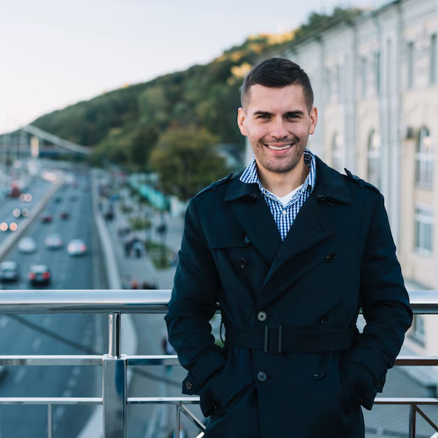 A guy posing for a headshot in an outdoor setting in a welcoming pose