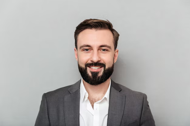 A headshot of a man posing with a smile in a formal attire