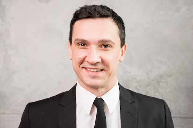 A traditional headshot of a guy posing with a warm grin