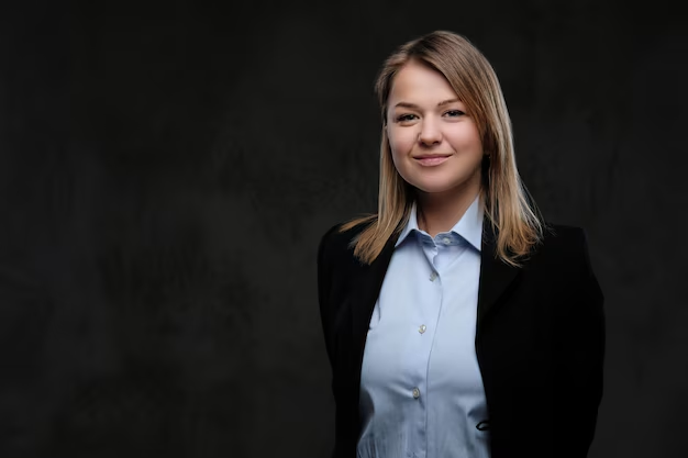 A woman posing for her modern corporate headshot against a solid-colored backdrop